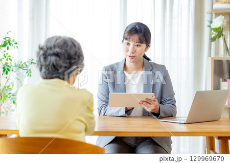 営業マンと話をするシニア女性 営業マンと話をするシニア女性 129969670