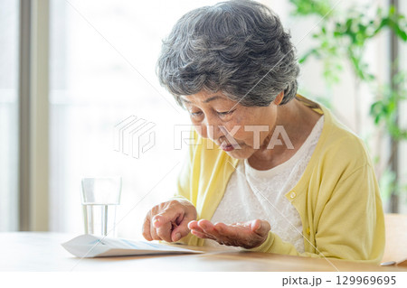 薬を飲むシニア女性 129969695