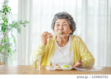 お弁当を食べるシニア女性 129969702
