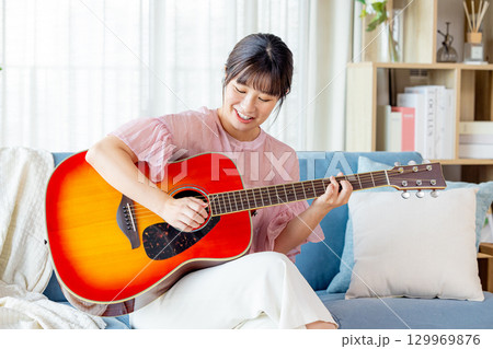 ギターを弾く若い女性 129969876