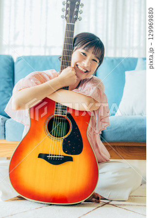 ギターを弾く若い女性 129969880