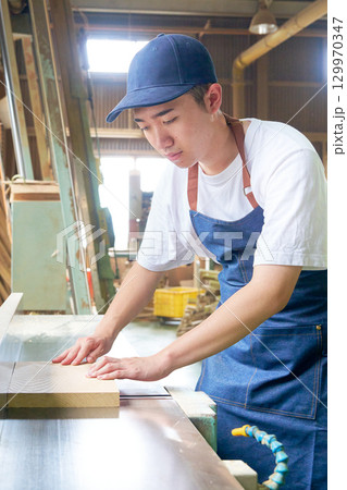 木工所で木材加工に取り組む若手作業員 129970347