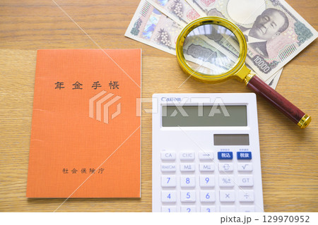 年金手帳と電卓やルーペ（整列） 129970952