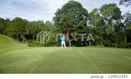 Golfers are putting golf in the evening golf course golf backglound. Golfer hitting golf ball. 129972265