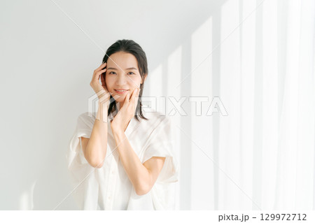 頬に手を当てる笑顔の女性 頬に手を当てる笑顔の女性 129972712