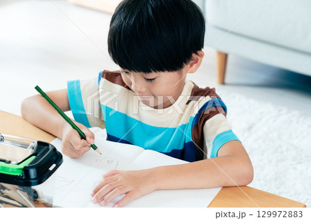 クワガタの観察日記を書く小学生男子 129972883