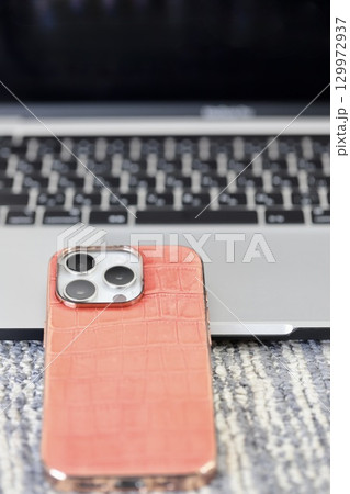 ノートパソコンのキーボードの前に置いたスマホ ノートパソコンのキーボードの前に置いたスマホ 129972937