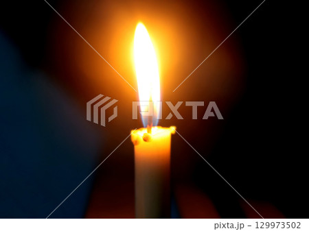 Burning Candle Flame in Darkness Symbolizing Light and Hope Burning Candle Flame in Darkness Symbolizing Light and Hope 129973502