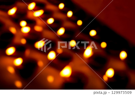 Blurred Rows of Lit Clay Oil Lamps Creating Warm Festival Glow 129973509