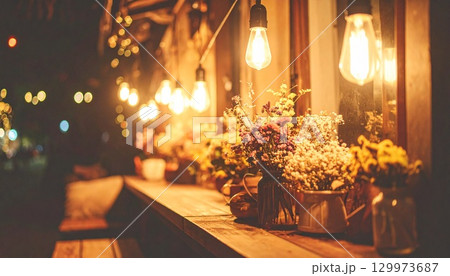 夜のカフェテラス：きらめく電球と花々 129973687