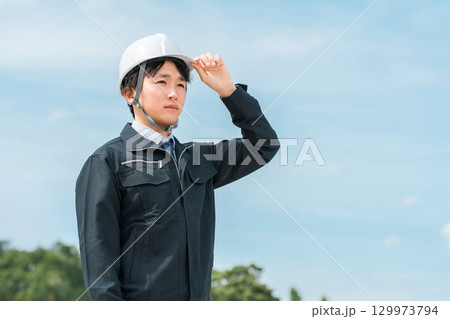 公園・森林にいる作業着姿の若いアジア人男性（林業・電気工事士・保守・点検） 129973794