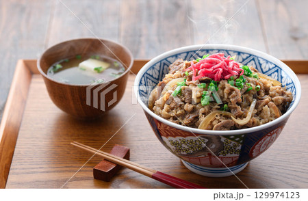 熱々の牛丼定食と味噌汁 漬物を添えた和食の食卓 日本の伝統的なランチやディナーのイメージ 129974123