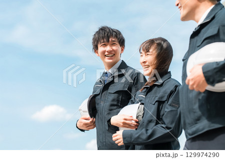 作業現場を歩く作業着姿の男女の作業員（建築業,運送業,土木業,ゼネコン） 129974290