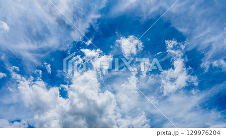 太陽のハロ現象と、二層になって流れるたくさんの白い雲 129976204