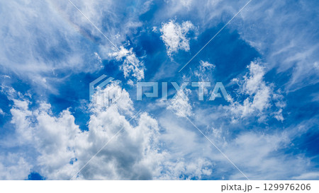太陽のハロ現象と、二層になって流れるたくさんの白い雲 129976206
