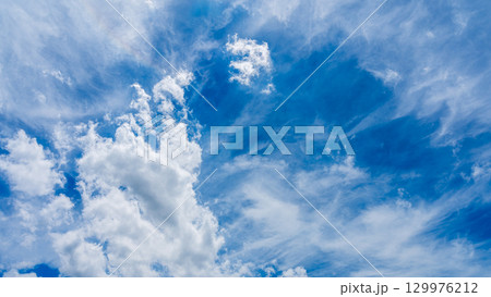 太陽のハロ現象と、二層になって流れるたくさんの白い雲 129976212