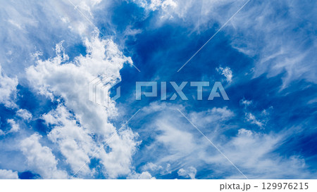 太陽のハロ現象と、二層になって流れるたくさんの白い雲 129976215