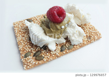 Crispy grain breads with seeds, cheese, ricotta and berries, marmalade. Breakfast and healthy eating. 129976857