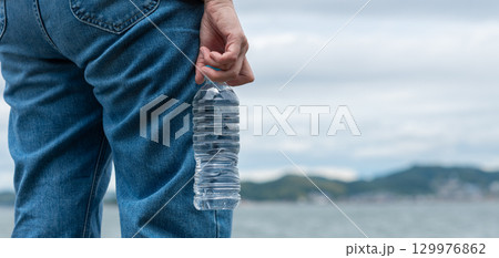 ペットボトルの水を持っている人 129976862