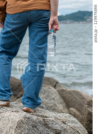 ペットボトルの水を持っている人 129976866