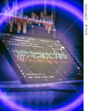Tablet showing volatile stock chart in neon light 129977192