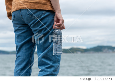 ペットボトルの水を持っている人 129977274