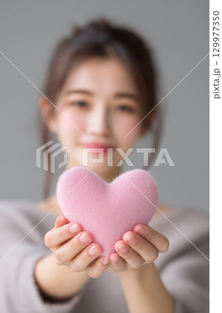 【縦写真】ハート型のオブジェを持つ女性 【縦写真】ハート型のオブジェを持つ女性 129977350