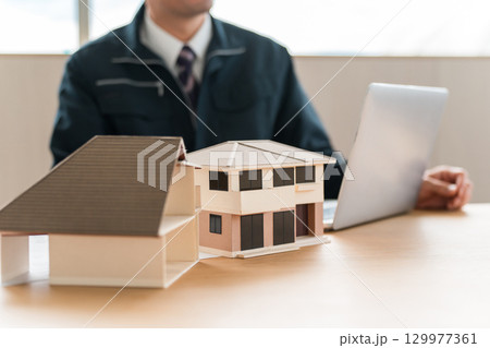 住宅模型,設計図の前で会議,ミーティングをするビジネスマン 129977361
