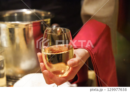 飲食店で、よく冷えた白ワインを注ぐ人 129977638
