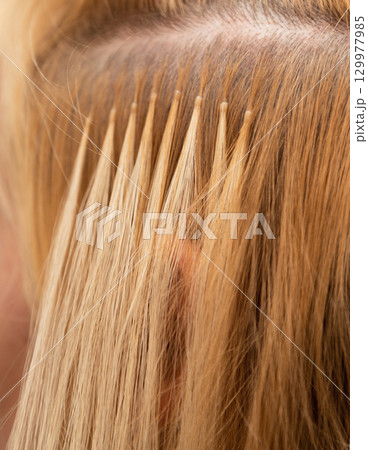 The process of blonde hair extensions. Beauty salon. Hair encapsulation. Hair extensions 129977985