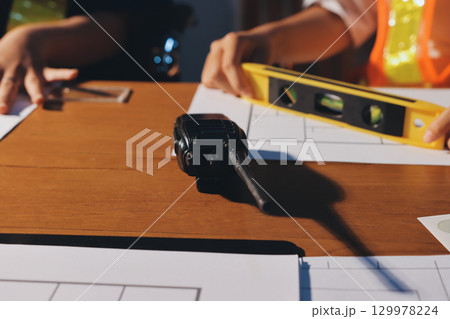 Closeup of team of industrial engineers meeting analyze machinery blueprints consult project on table in manufacturing factory. Working in manufacturing plant or production plant. 129978224