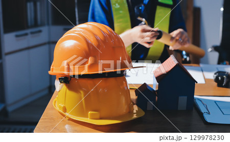 Closeup of team of industrial engineers meeting analyze machinery blueprints consult project on table in manufacturing factory. Working in manufacturing plant or production plant. Closeup of team of industrial engineers meeting analyze machinery blueprints consult project on table in manufacturing factory. Working in manufacturing plant or production plant. 129978230