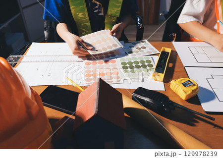 Closeup of team of industrial engineers meeting analyze machinery blueprints consult project on table in manufacturing factory. Working in manufacturing plant or production plant. 129978239