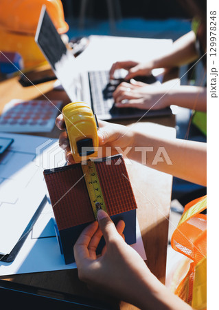 Closeup of team of industrial engineers meeting analyze machinery blueprints consult project on table in manufacturing factory. Working in manufacturing plant or production plant. 129978248