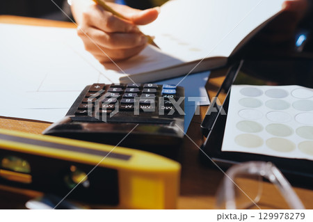 Closeup of team of industrial engineers meeting analyze machinery blueprints consult project on table in manufacturing factory. Working in manufacturing plant or production plant. 129978279