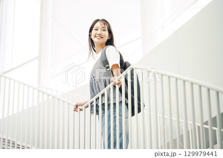 リュックを背負って一人で出かける女性 129979441