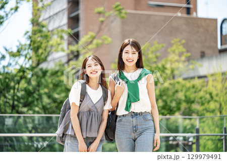友達と楽しく話しながら校内を歩く女子大生 129979491
