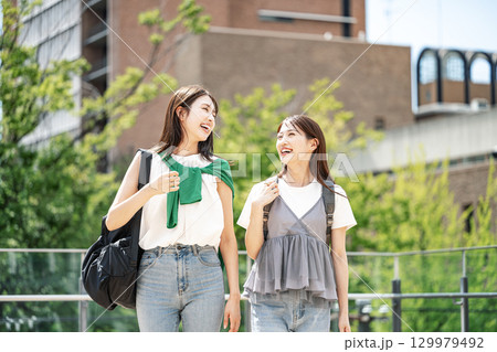 友達と楽しく話しながら校内を歩く女子大生 129979492