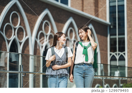 友達と楽しく話しながら校内を歩く女子大生 129979493