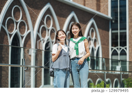 友達と楽しく話しながら校内を歩く女子大生 129979495