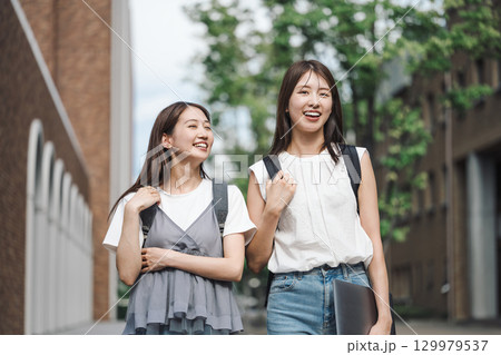 学校内の敷地を友達と一緒に歩く女子大生 129979537