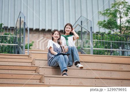 学校内の階段に座る女子大生のポートレート 129979691