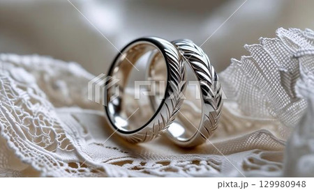 白いレースの上に並んだ結婚指輪のクローズアップ 129980948