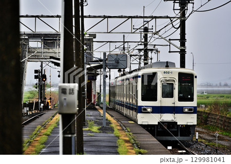 雨のホームと電車 129981041