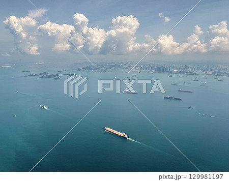 Aerial view of Singapore's coastline and shipping activity during daytime over calm waters 129981197