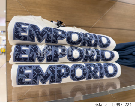 Emporio Armani branded t-shirts stacked neatly on display in a retail store Emporio Armani branded t-shirts stacked neatly on display in a retail store 129981224