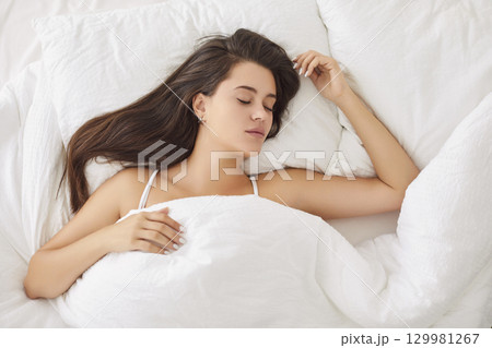 Peaceful Caucasian woman sleeping comfortably in bed with soft pillow and blanket early in morning. Peaceful Caucasian woman sleeping comfortably in bed with soft pillow and blanket early in morning. 129981267