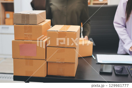 Portrait of Starting small businesses SME owners, two Asian woman check online orders Selling products working with boxs freelance work at home office, sme business online small medium enterprise 129981777