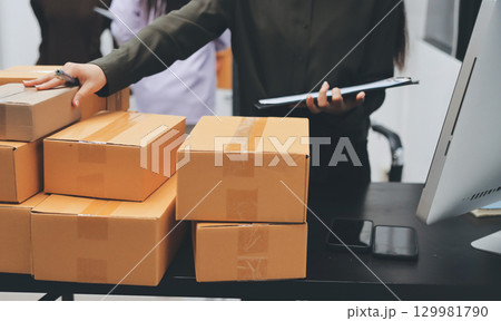 Portrait of Starting small businesses SME owners, two Asian woman check online orders Selling products working with boxs freelance work at home office, sme business online small medium enterprise 129981790