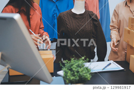 Portrait of Starting small businesses SME owners, two Asian woman check online orders Selling products working with boxs freelance work at home office, sme business online small medium enterprise Portrait of Starting small businesses SME owners, two Asian woman check online orders Selling products working with boxs freelance work at home office, sme business online small medium enterprise 129981917